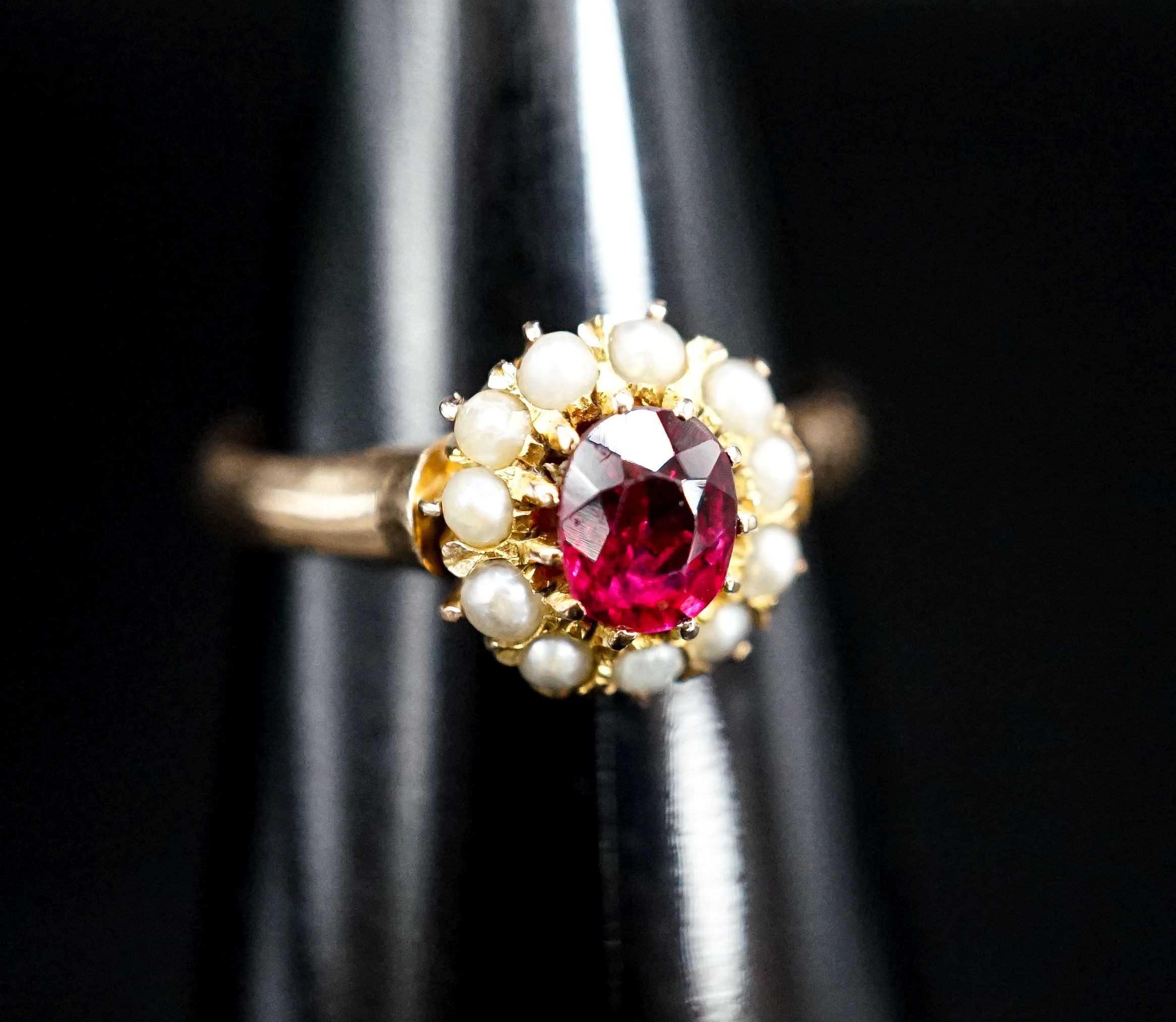 A yellow metal, ruby and seed pearl circular cluster ring, size N, gross weight 3.2 grams.